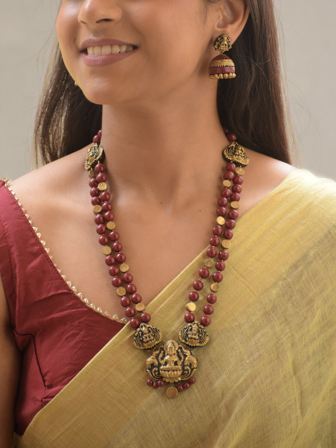 Rajyalakshmi - Handmade Terracotta Maroon Lakshmi Necklace Set – Dual Strand Beads with Antique Gold Motifs Matching Earrings